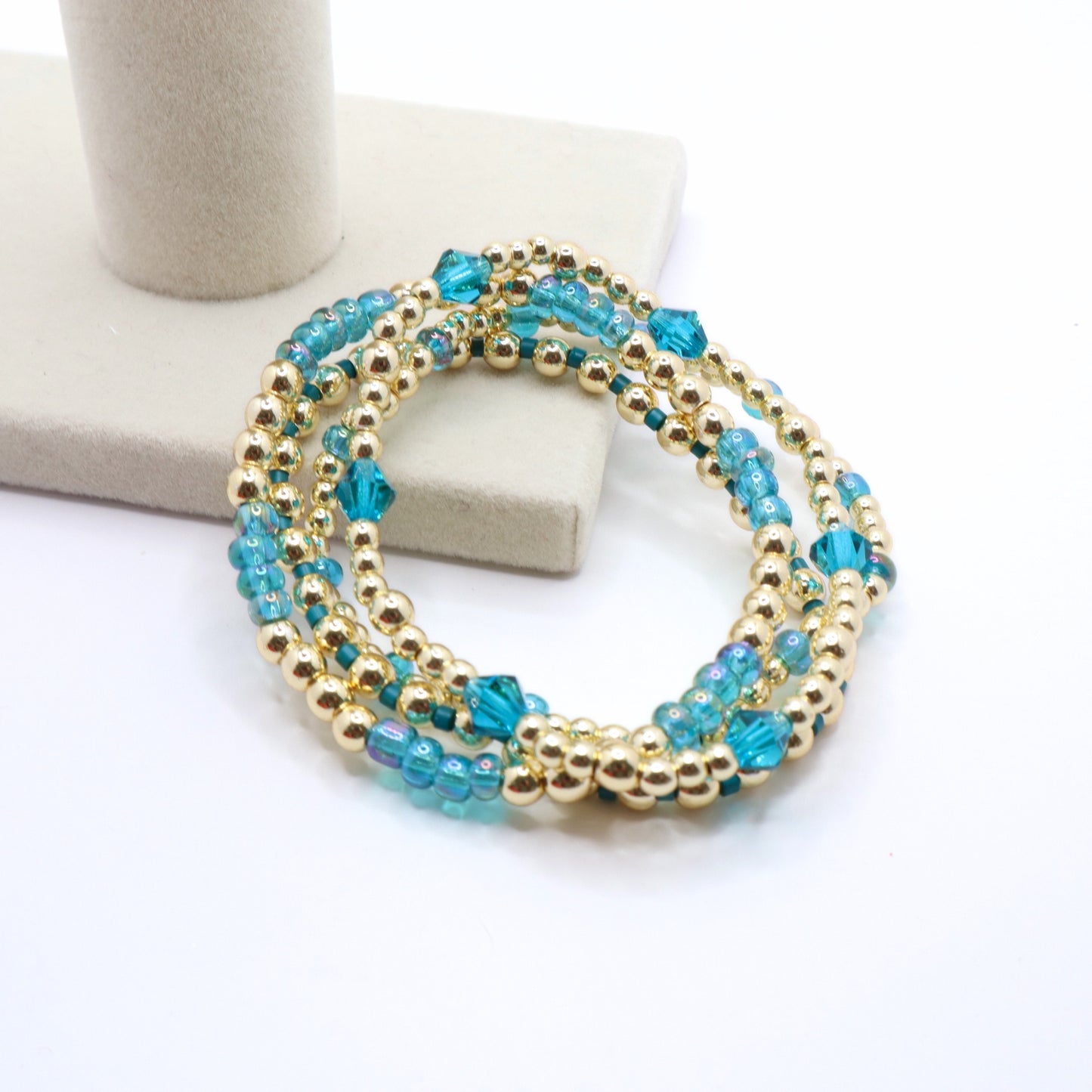 Delicate stackable bracelets featuring periwinkle glass beads and gold hematite.