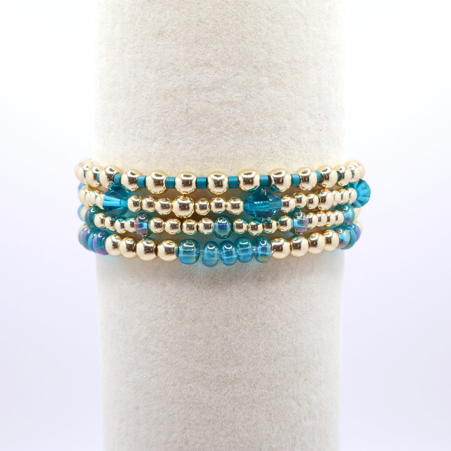 Three coordinating blue and gold stretch bracelets for stacking.