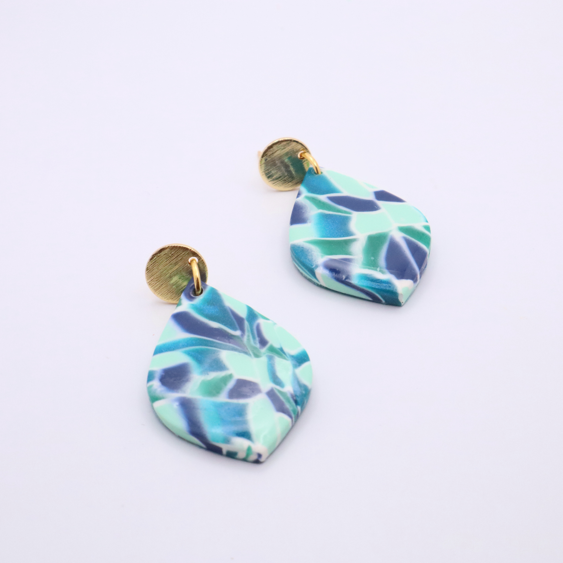 Angled view of ocean-inspired mosaic teardrop earrings with 18k gold plated studs on white background