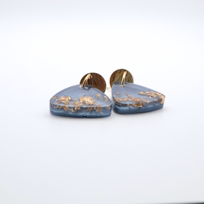 Blue resin earrings with gold flakes on a white background