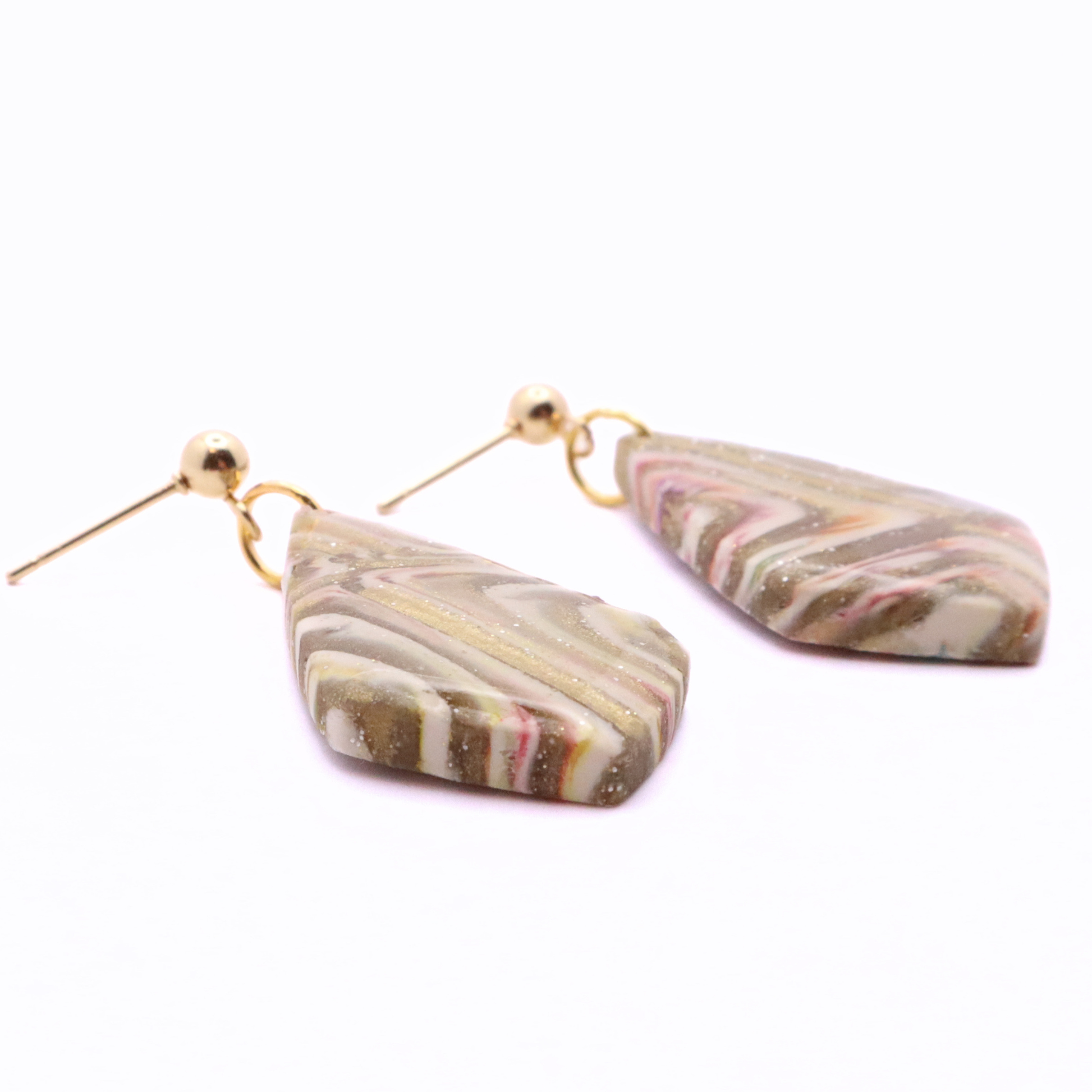 Side view of handmade clay dangle earrings showing thickness and lightweight design with stainless steel stud hardware