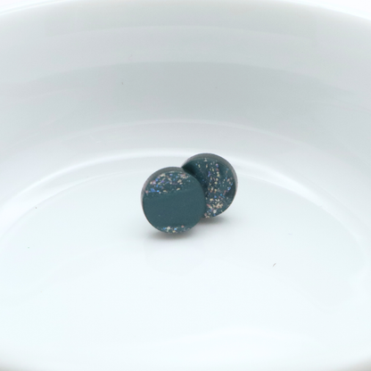 Pair of round earrings with a speckled design on a white background