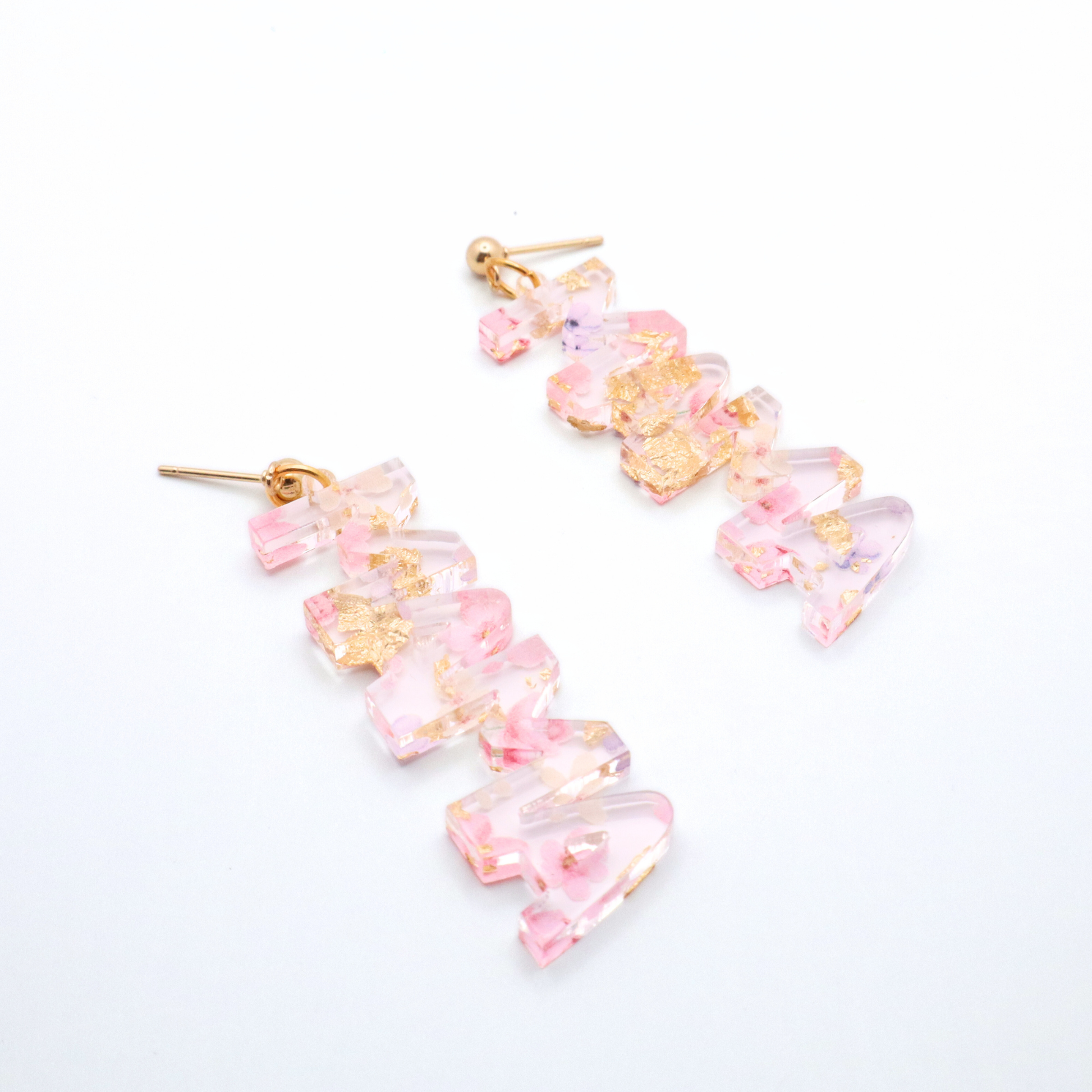 Pair of pink floral mama earrings on a white background