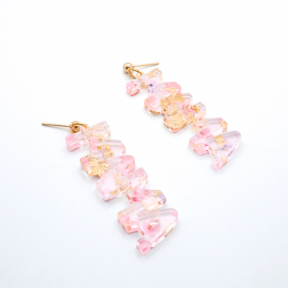 Pair of pink floral mama earrings on a white background