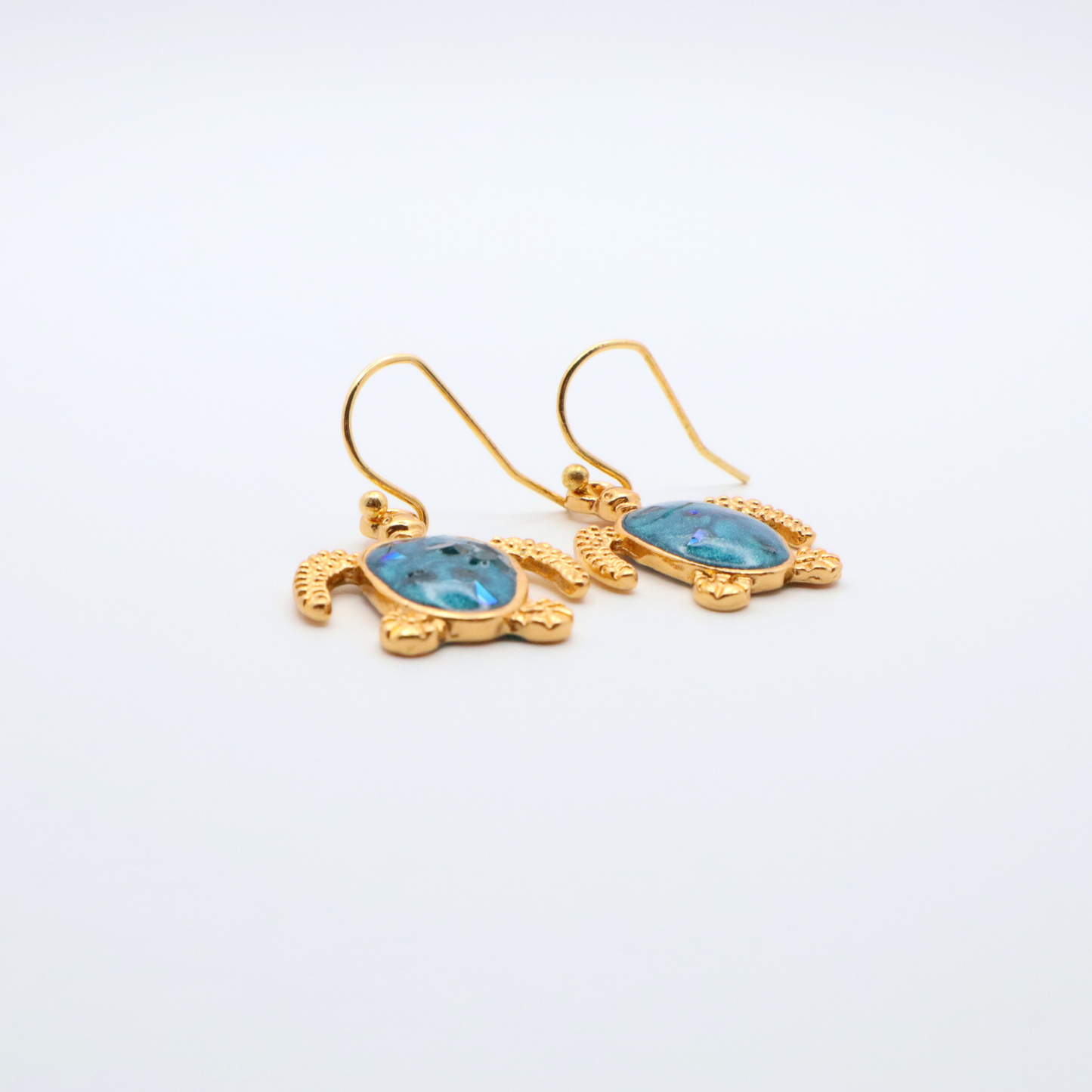 Gold turtle-shaped earrings with teal blue resin on a white background