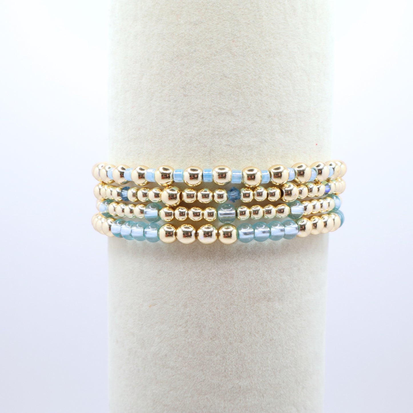 Elegant bracelet stack featuring gold-tone hematite beads with sky blue accents.