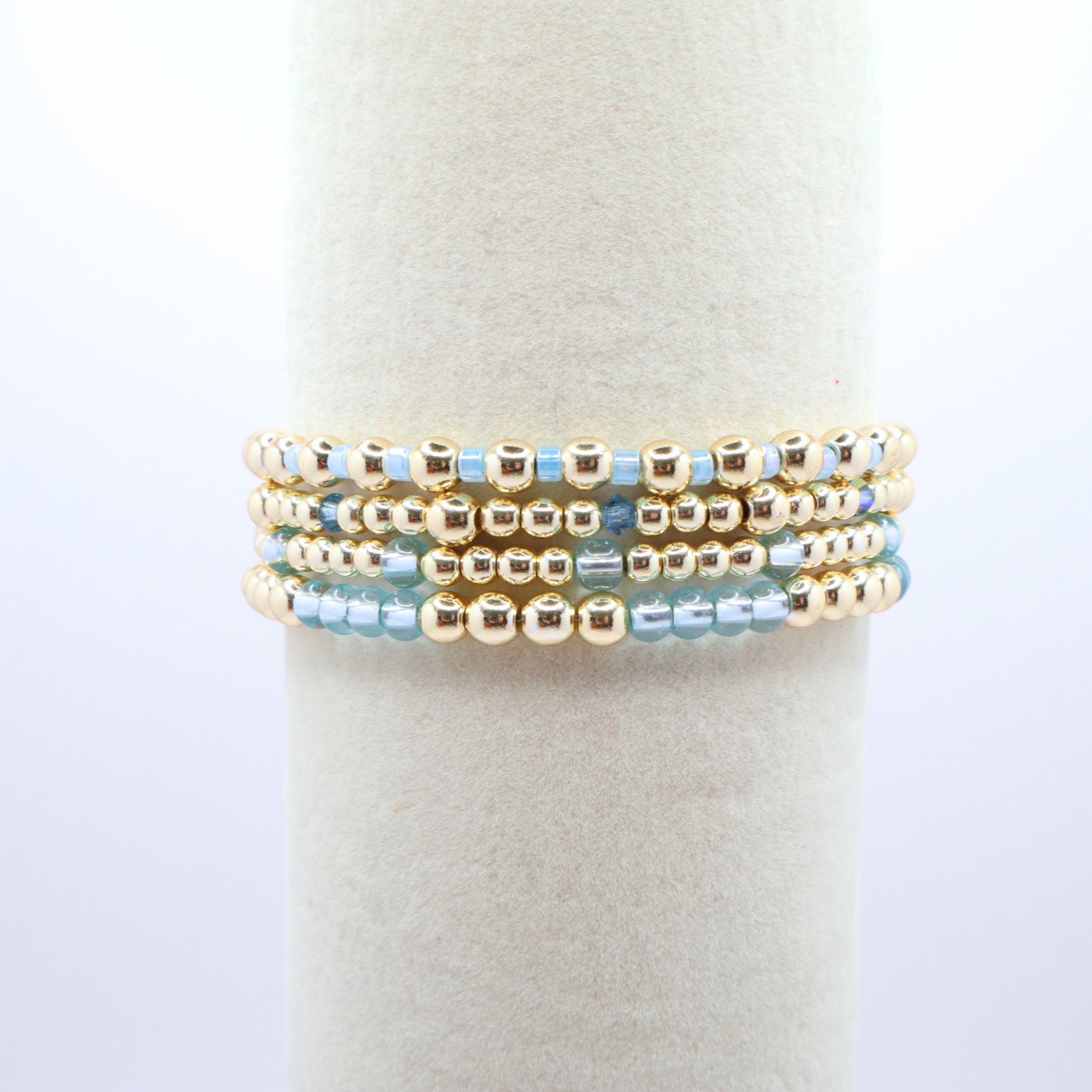 Elegant bracelet stack featuring gold-tone hematite beads with sky blue accents.