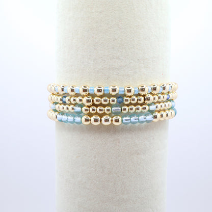 Elegant bracelet stack featuring gold-tone hematite beads with sky blue accents.