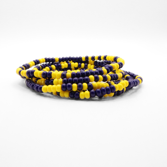 Set of six navy blue and yellow seed bead stretch bracelets featuring random navy blue and yellow seed beads on a white background