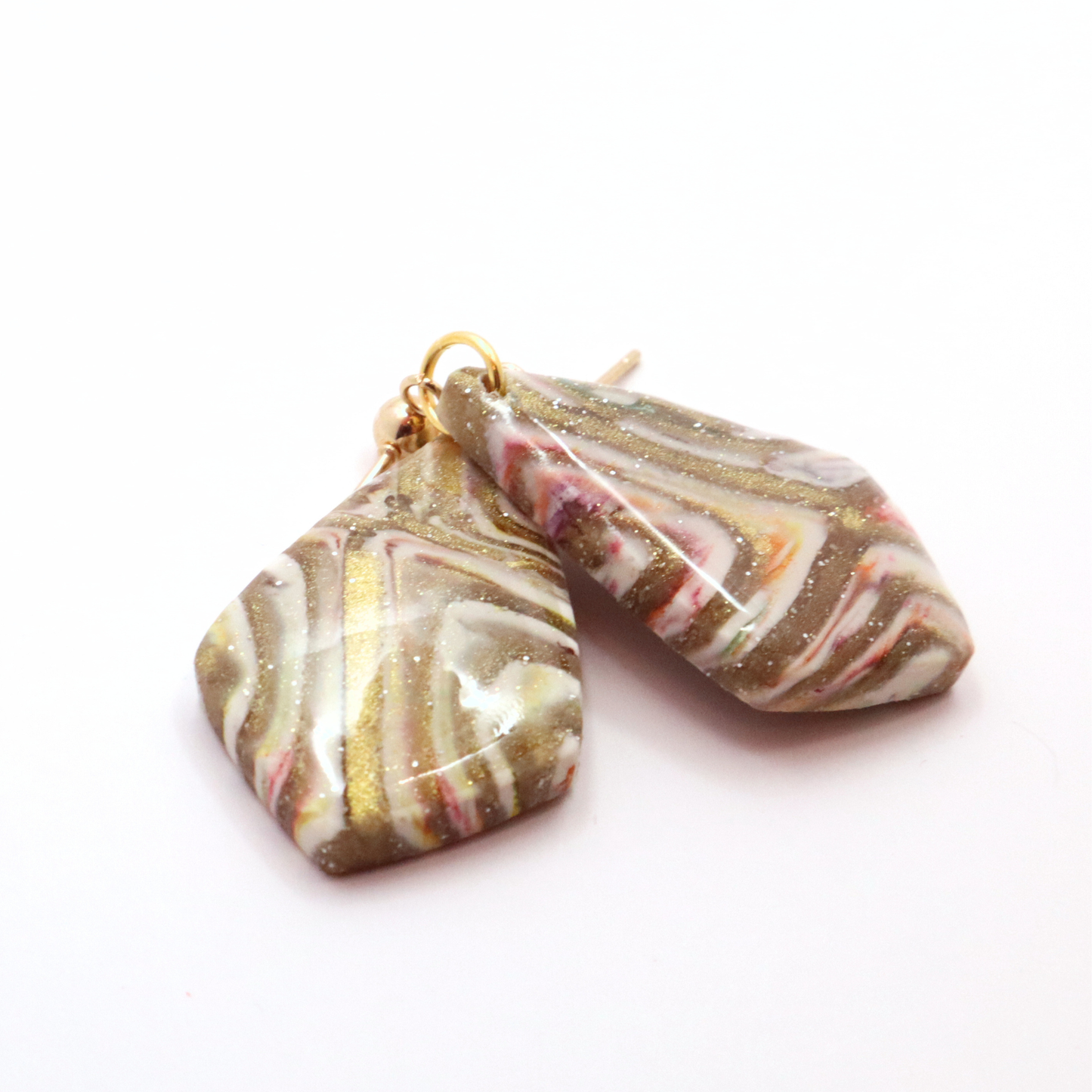 Artistic marbled polymer clay earrings with soft neutral color palette and gold accents on stainless steel posts
