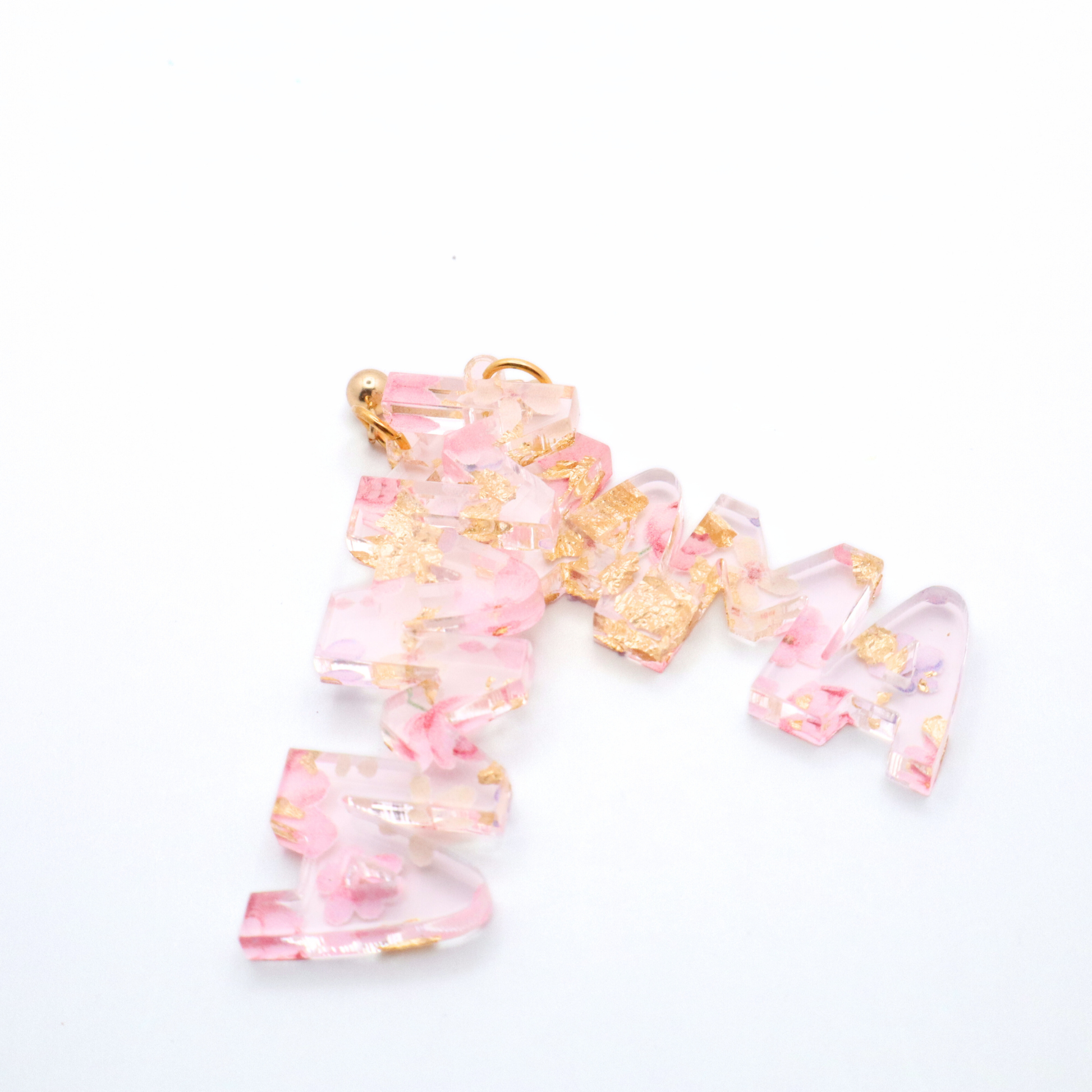 Pink and gold mama earrings on a white background