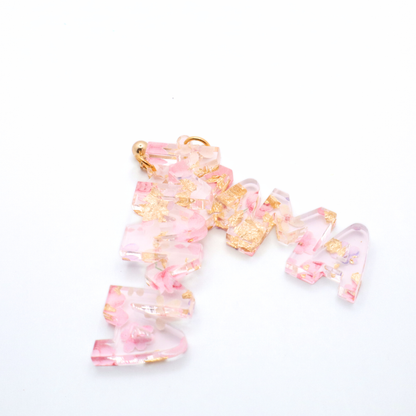 Pink and gold mama earrings on a white background