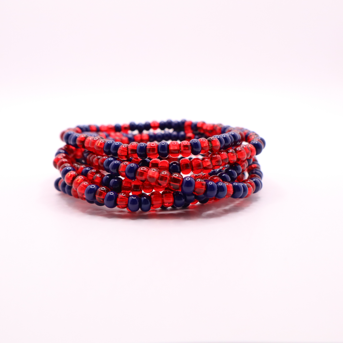 Set of six navy blue and red seed bead stretch bracelets featuring random navy blue and red seed beads on a white background