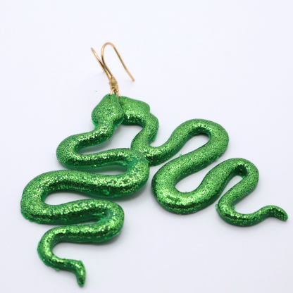 Green glitter snake-shaped earrings on a white background