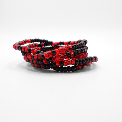 Set of six red and black seed bead stretch bracelets featuring random red and black seed beads on a white background