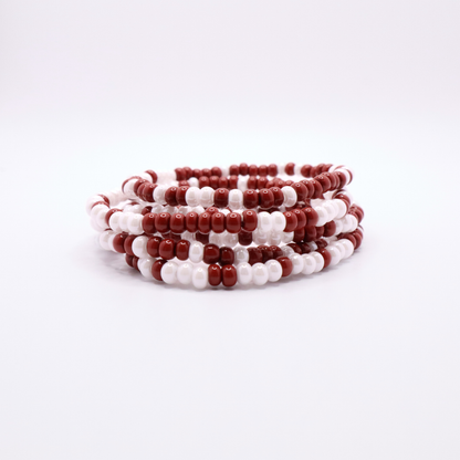 Set of six crimson and white seed bead stretch bracelets featuring random crimson and white seed beads on a white background