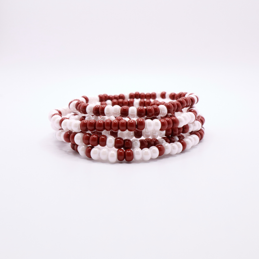 Set of six crimson and white seed bead stretch bracelets featuring random crimson and white seed beads on a white background