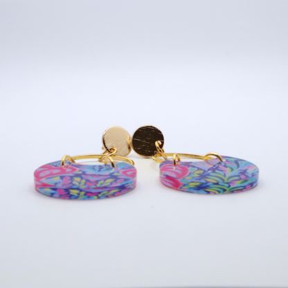 Side profile of acrylic dangle earrings showing thickness and glossy finish with colorful floral pattern and gold hoop with 18k gold plated posts
