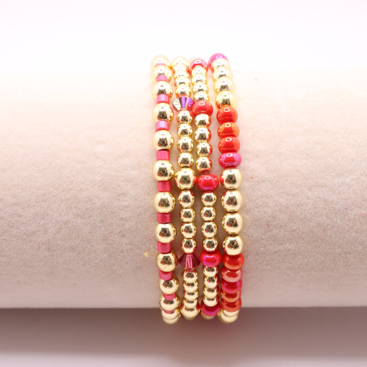 Four coordinating stretch bracelets featuring vibrant pink and coral glass beads.