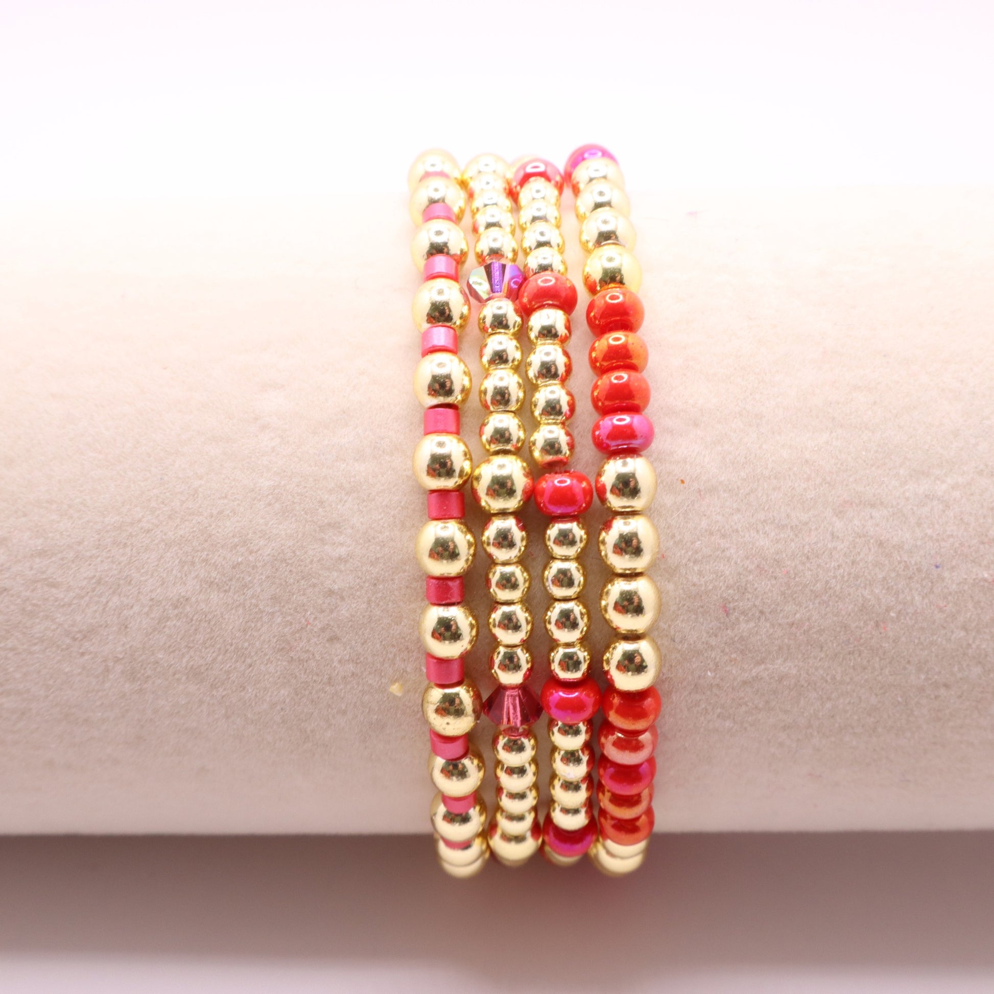Four coordinating stretch bracelets featuring vibrant pink and coral glass beads.