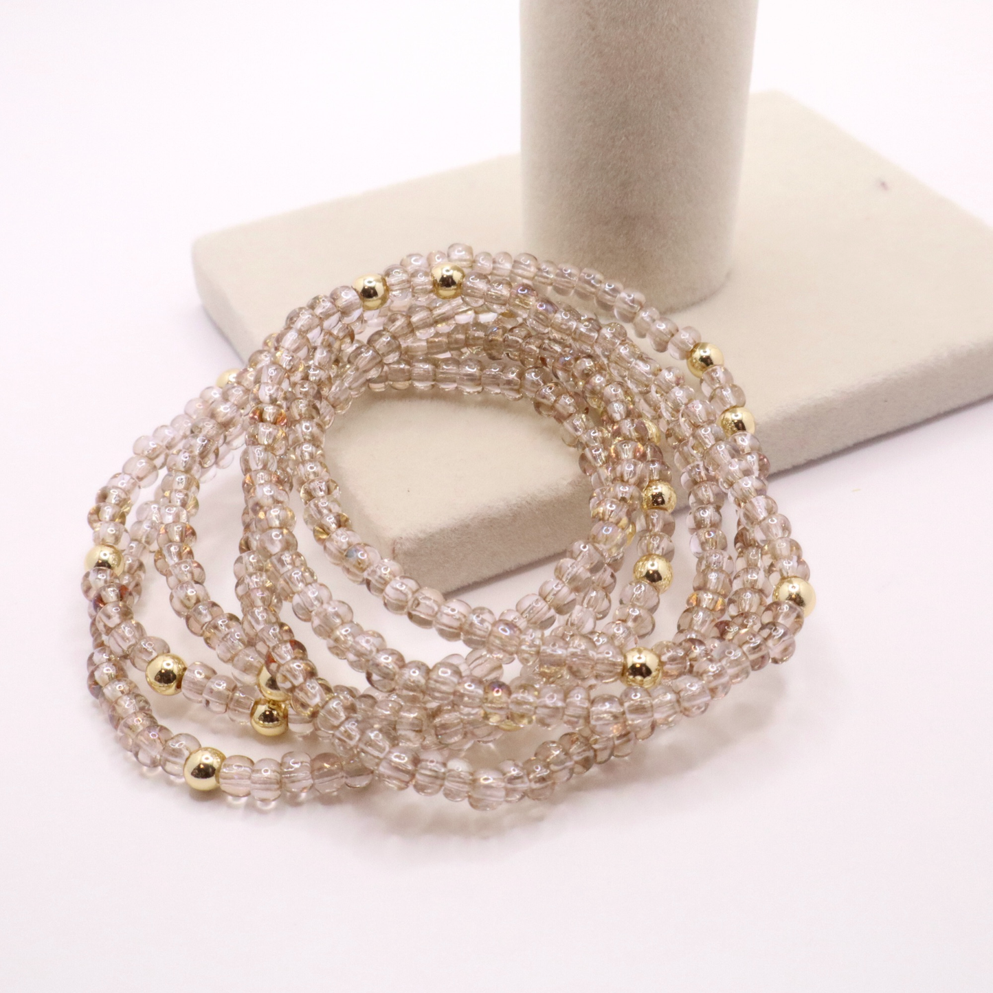set of six neutral gold tone seed bead bracelets featuring high quality neutral seed beads and golden hematite accent beads.  The stack is displayed on a white background.
