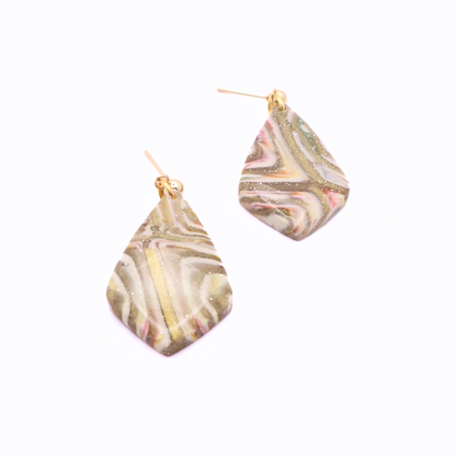 Abstract swirl pattern clay earrings with gold shimmer, neutral tones, and stainless steel stud posts on white background