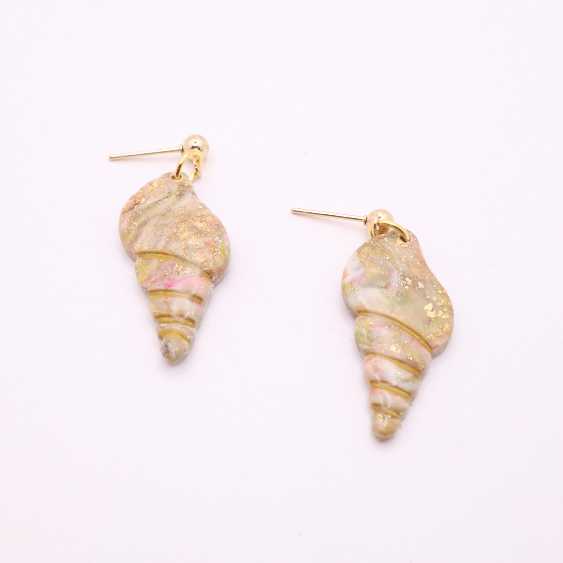 Neutral-toned seashell earrings with gold accents displayed flat on white background