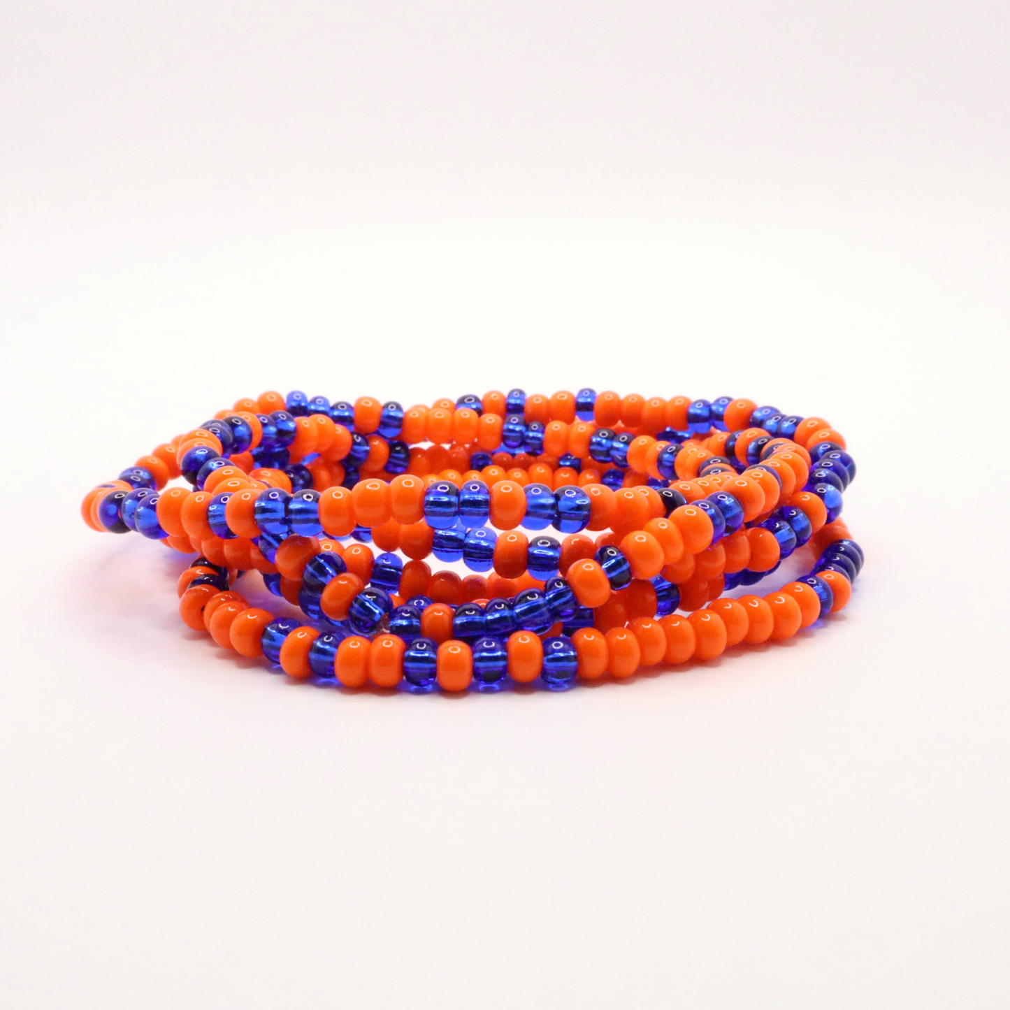 Set of six orange and blue and white seed bead stretch bracelets featuring random orange and blue seed beads on a white background