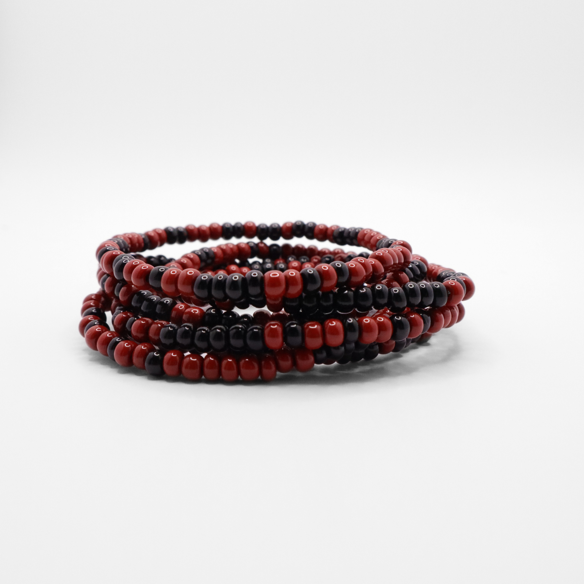 Set of six maroon and black seed bead stretch bracelets featuring random maroon and black seed beads on a white background