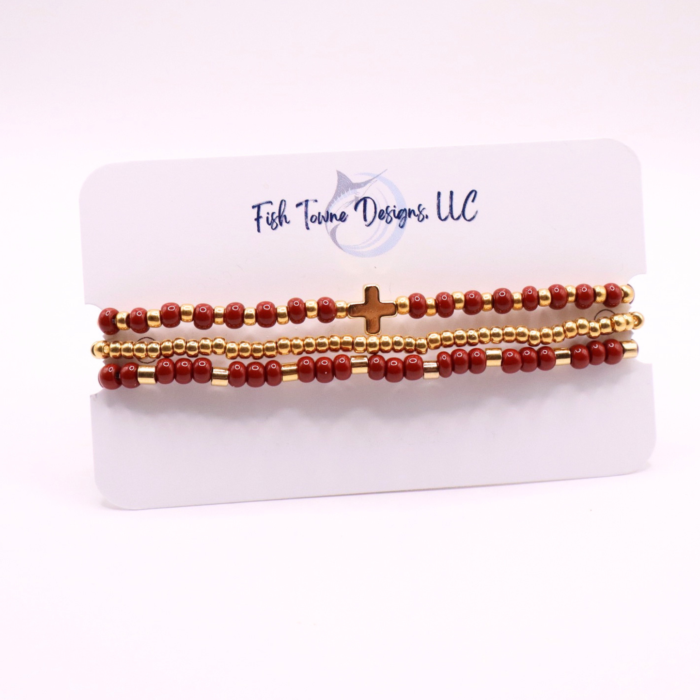 Three beaded bracelets with a cross charm on a card with 'Fish Twine Designs, LLC' branding.