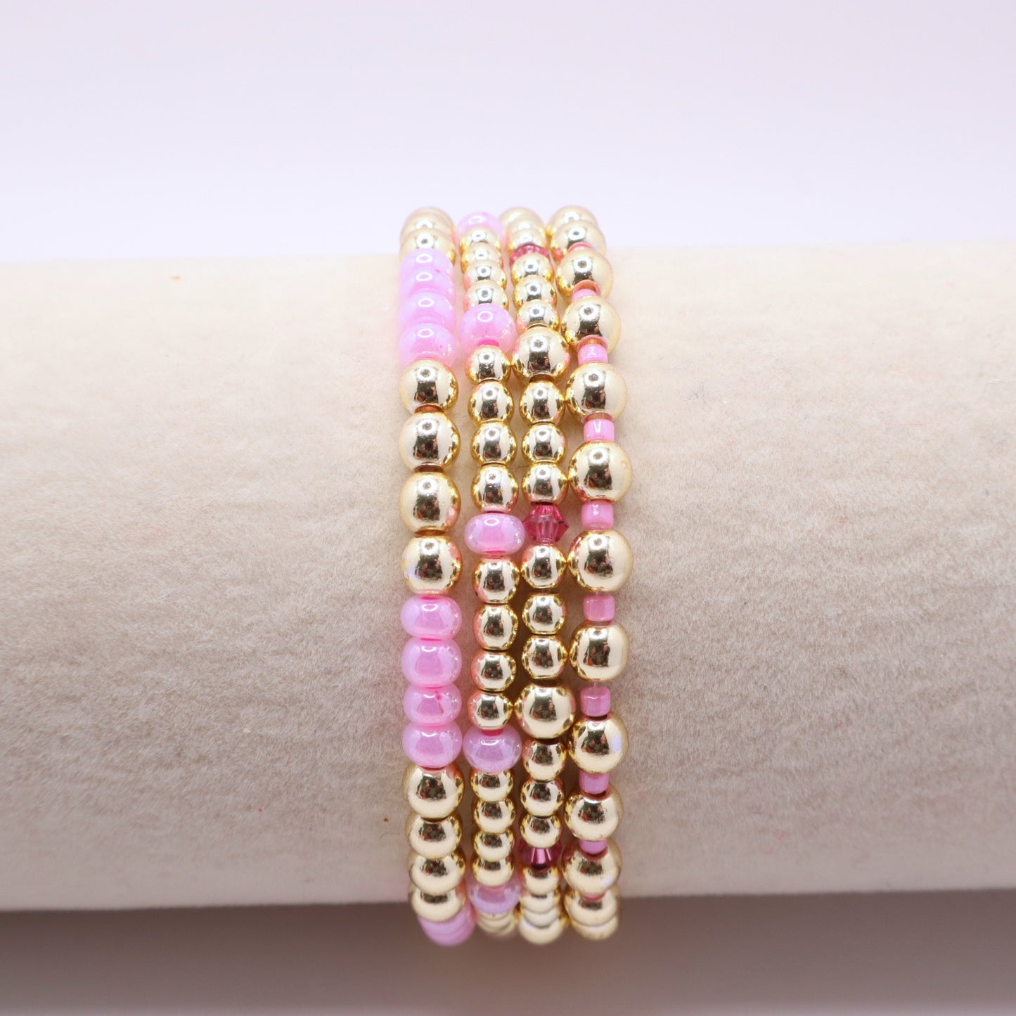Elegant bracelet stack featuring gold-tone hematite beads with soft pink accents.