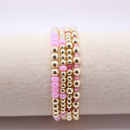 Elegant bracelet stack featuring gold-tone hematite beads with soft pink accents.