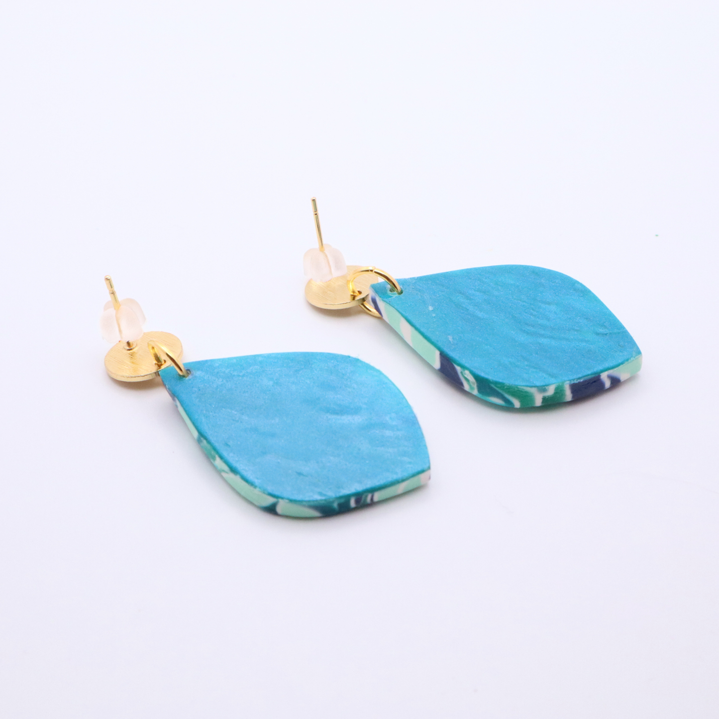 Close-up detail of mosaic pattern teardrop earrings with 18k gold plated studs on gold display stand