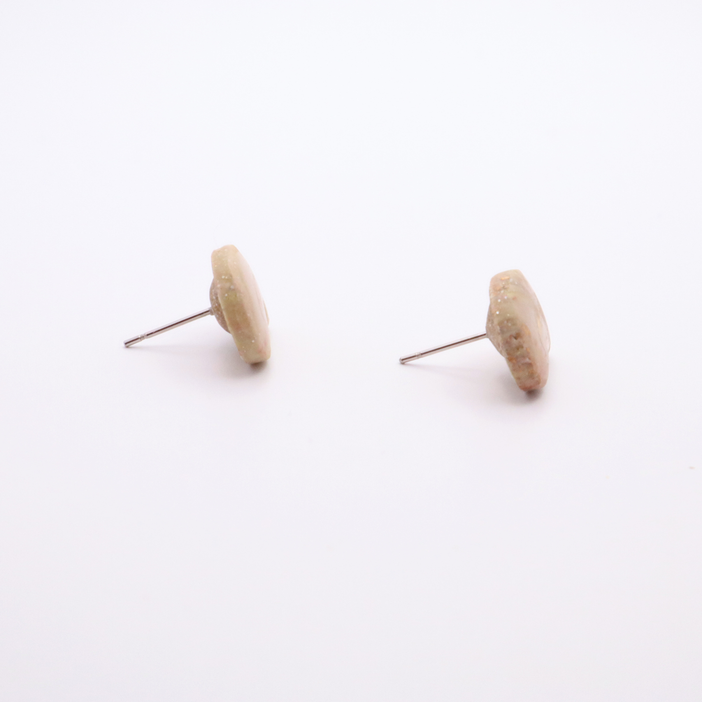 Side profile of shell stud earrings showing thickness and stainless steel posts