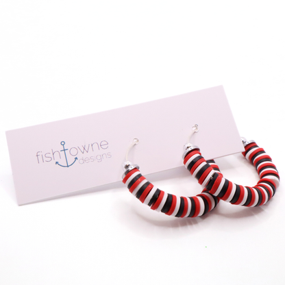 Red, white, and black heishi bead hoop earrings with silver accents displayed on a branded card against a white background