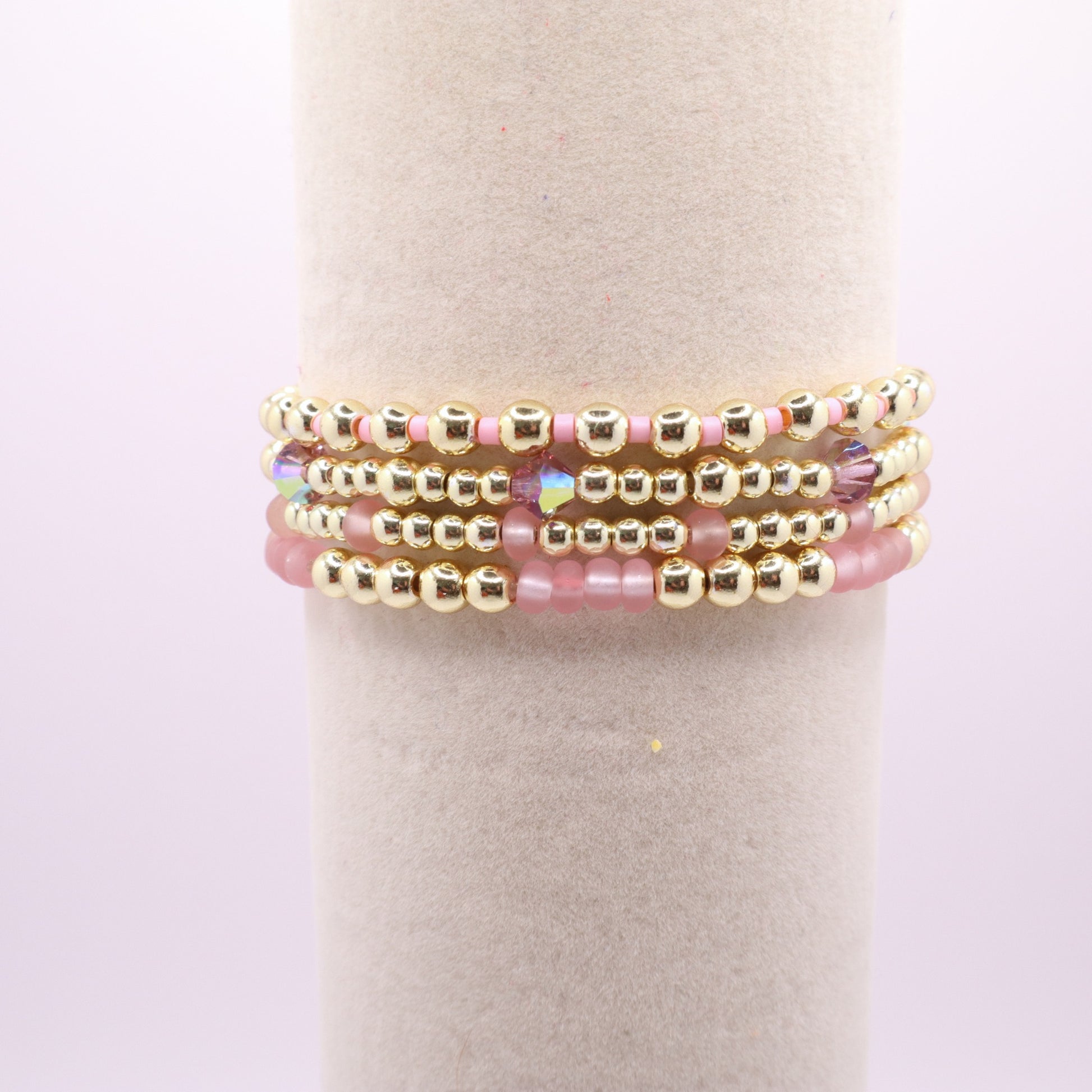 Gold and pink stretch bracelet set with four coordinating handmade bracelets.