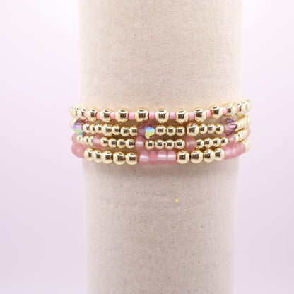 Gold and pink stretch bracelet set with four coordinating handmade bracelets.
