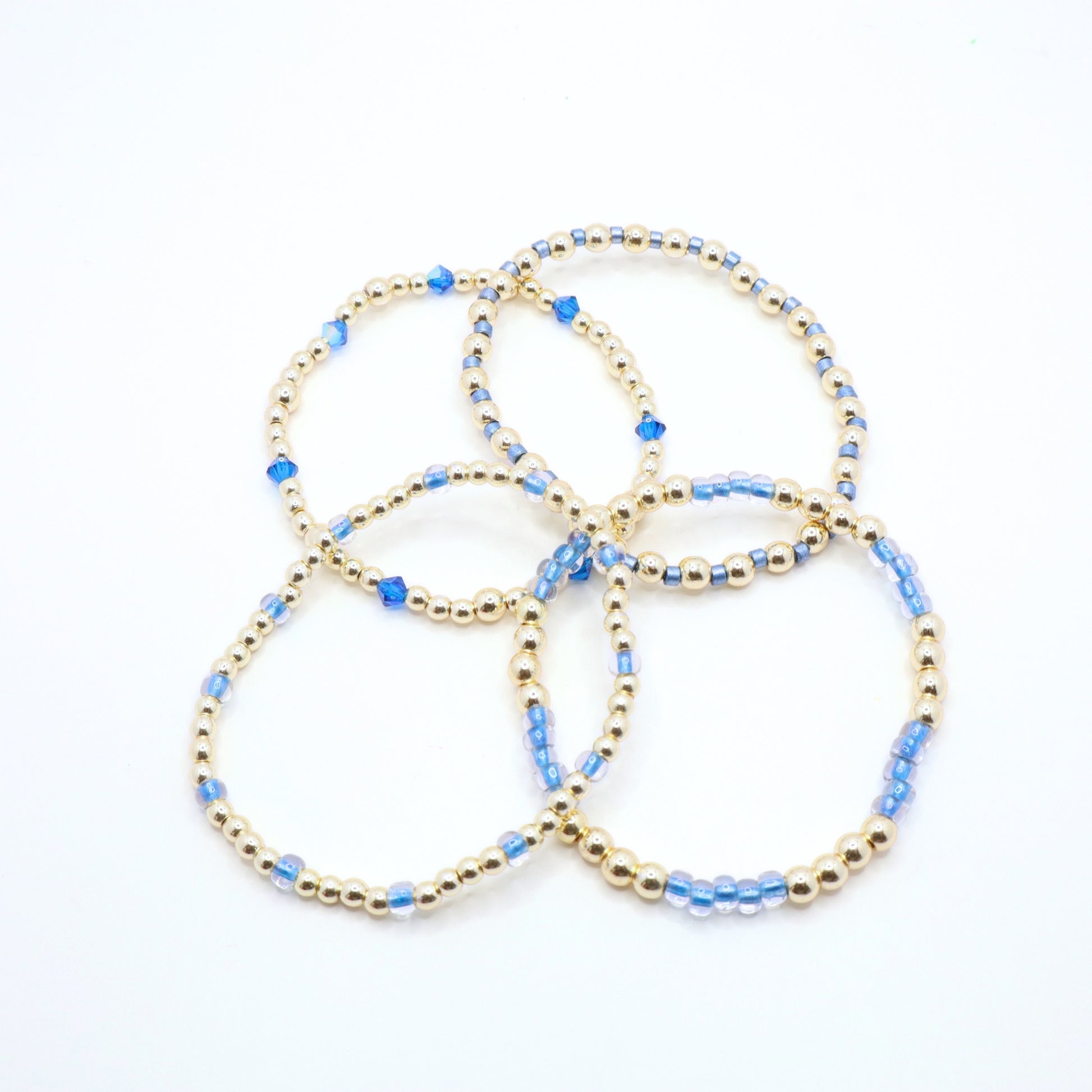 Delicate blue and gold hematite bracelet stack shown from multiple angles.