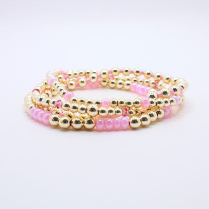 Stretch bracelet stack in pink and gold tones designed for layering and everyday wear.