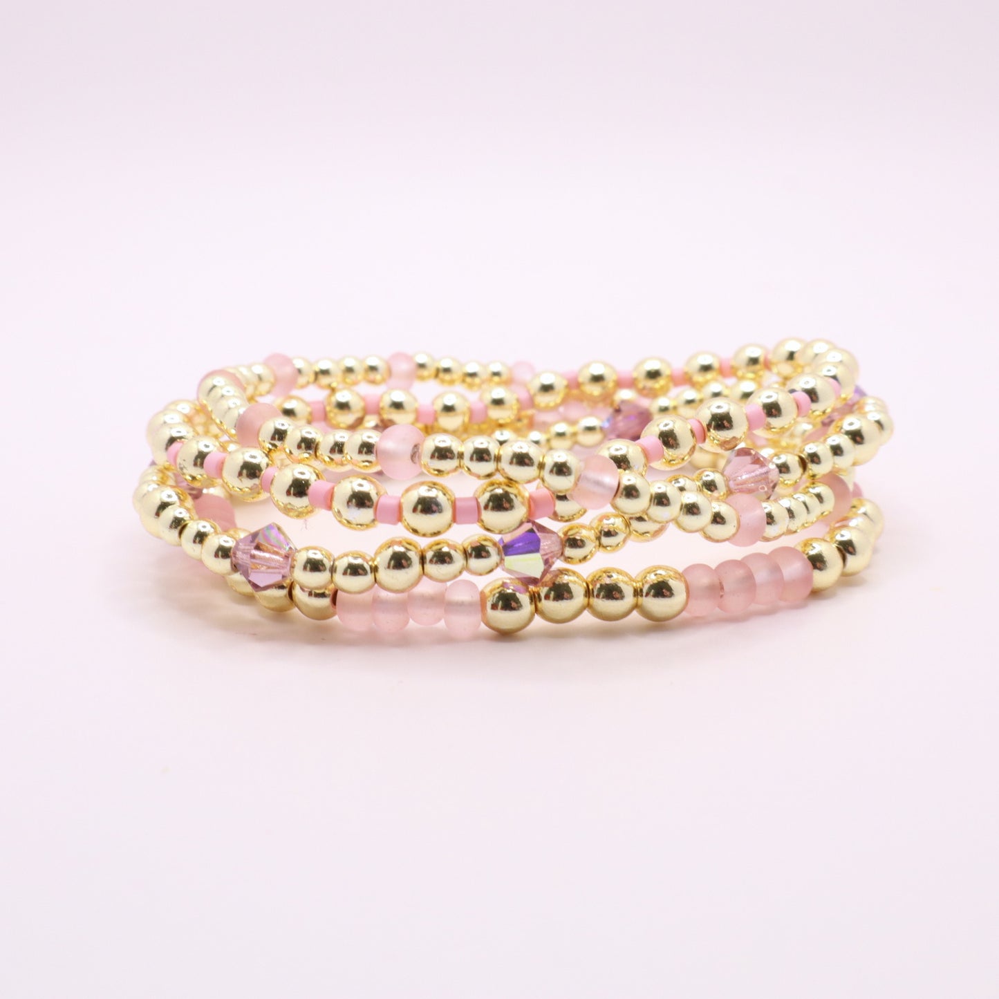 Handmade gold hematite bracelet collection featuring soft pink glass beads.