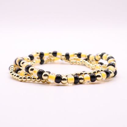 Black and gold beaded bracelet on a white background