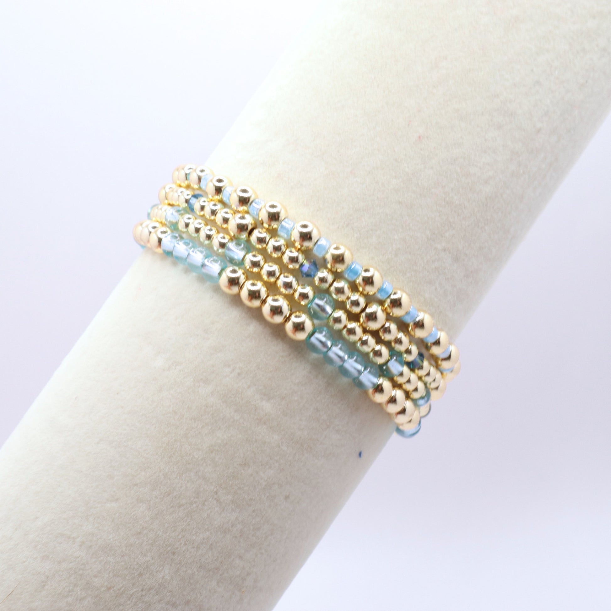 Handmade stretch bracelet set with polished gold hematite beads and light blue glass beads.