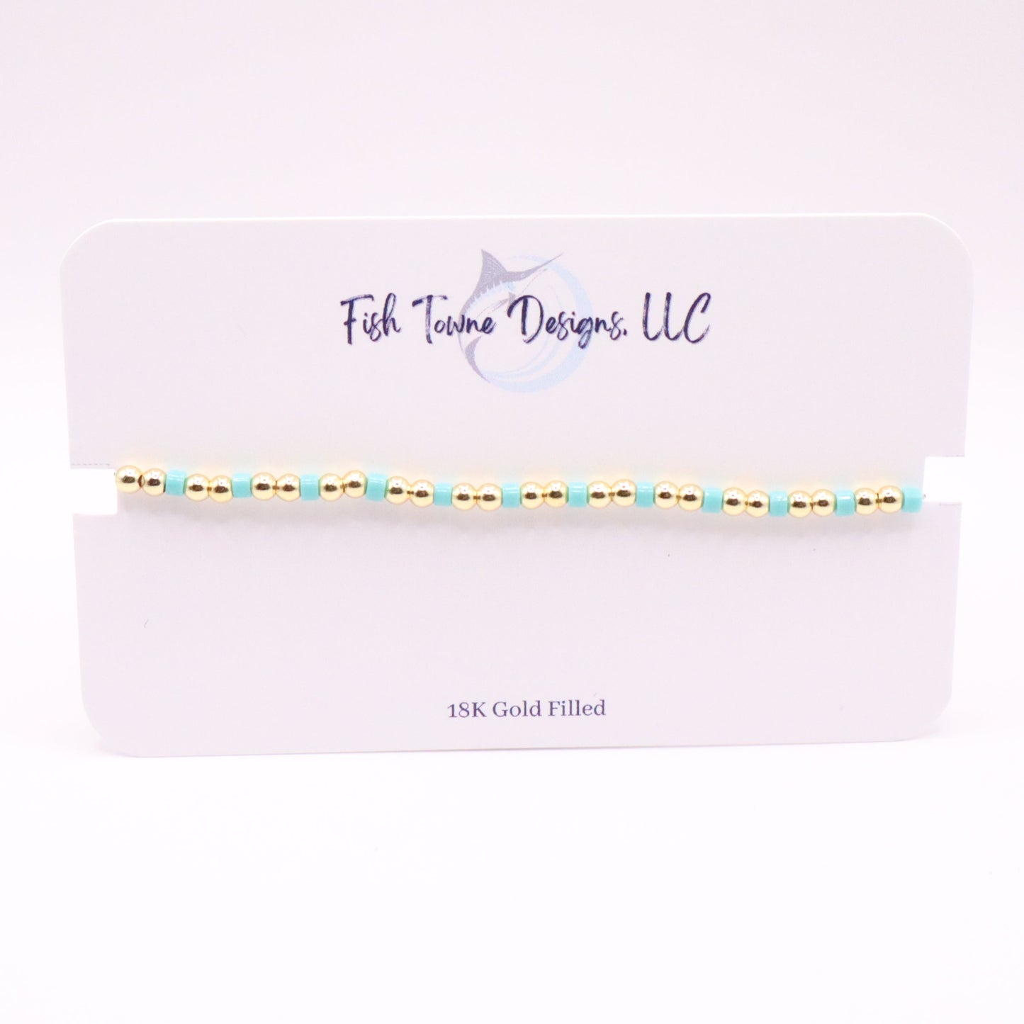 Gold and turquoise beaded bracelet on a Fish Towne Designs, LLC branded card.