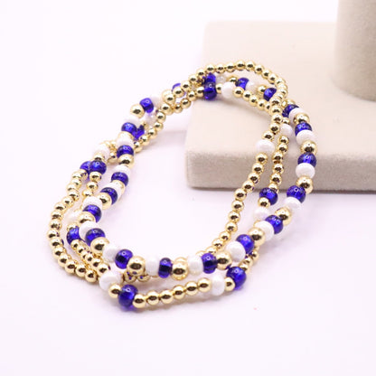 Gold and blue beaded necklace on a white stand with a white background