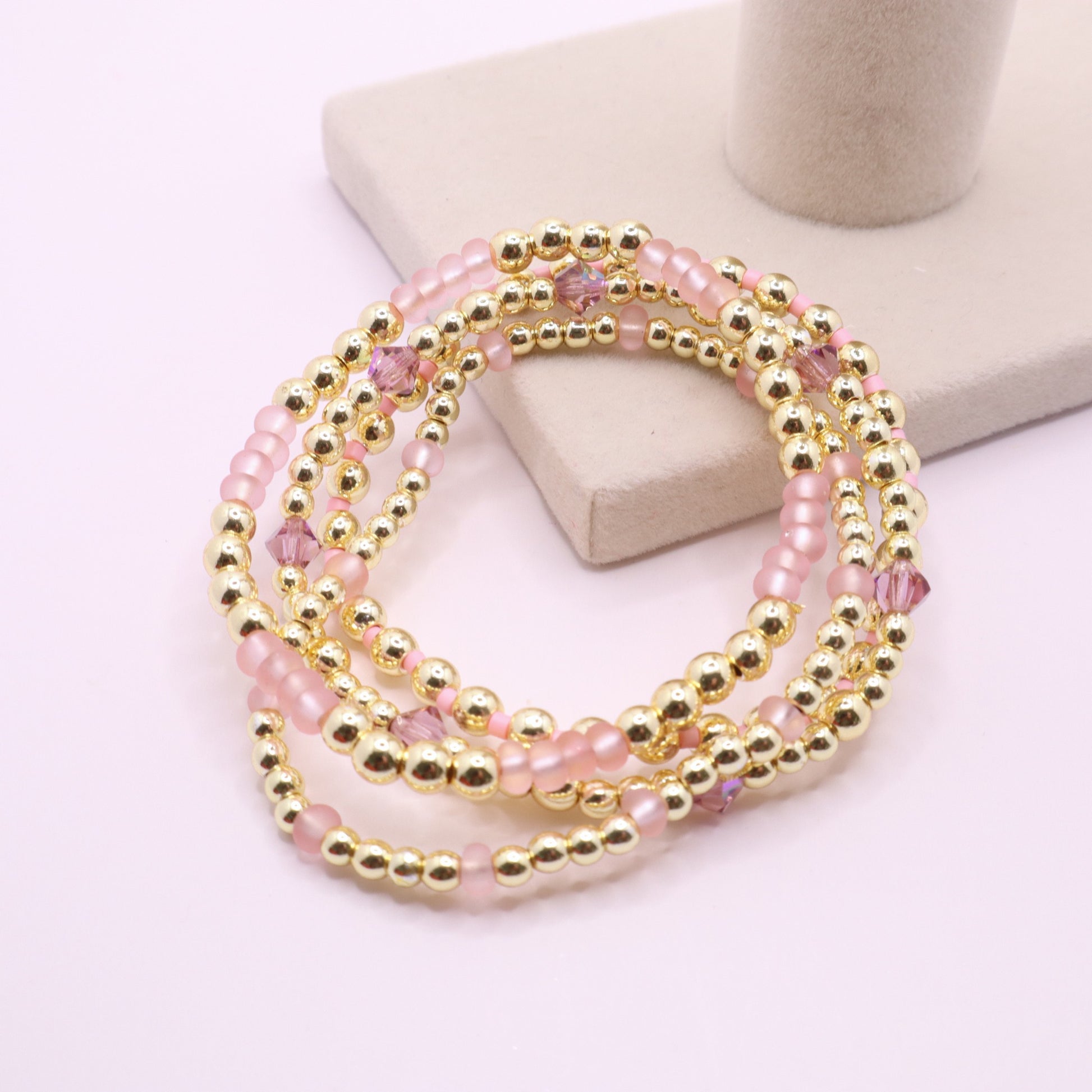 Four coordinating stretch bracelets with blush pink beads and crystal accents.