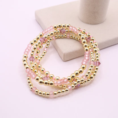 Four coordinating stretch bracelets with blush pink beads and crystal accents.