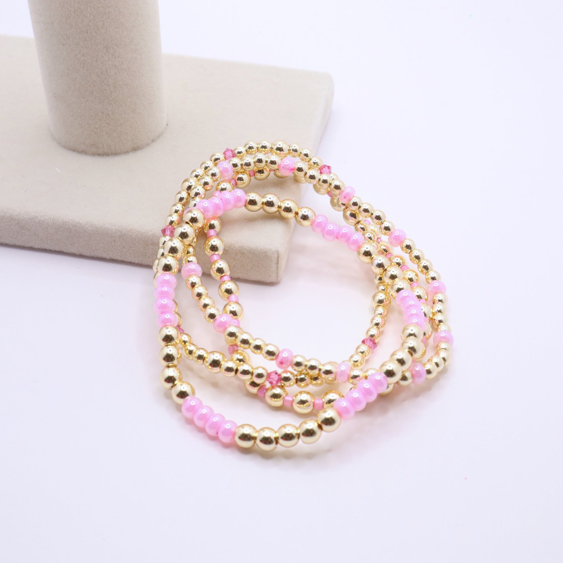 Gold hematite bracelet set accented with pink beads and coordinating crystal elements.