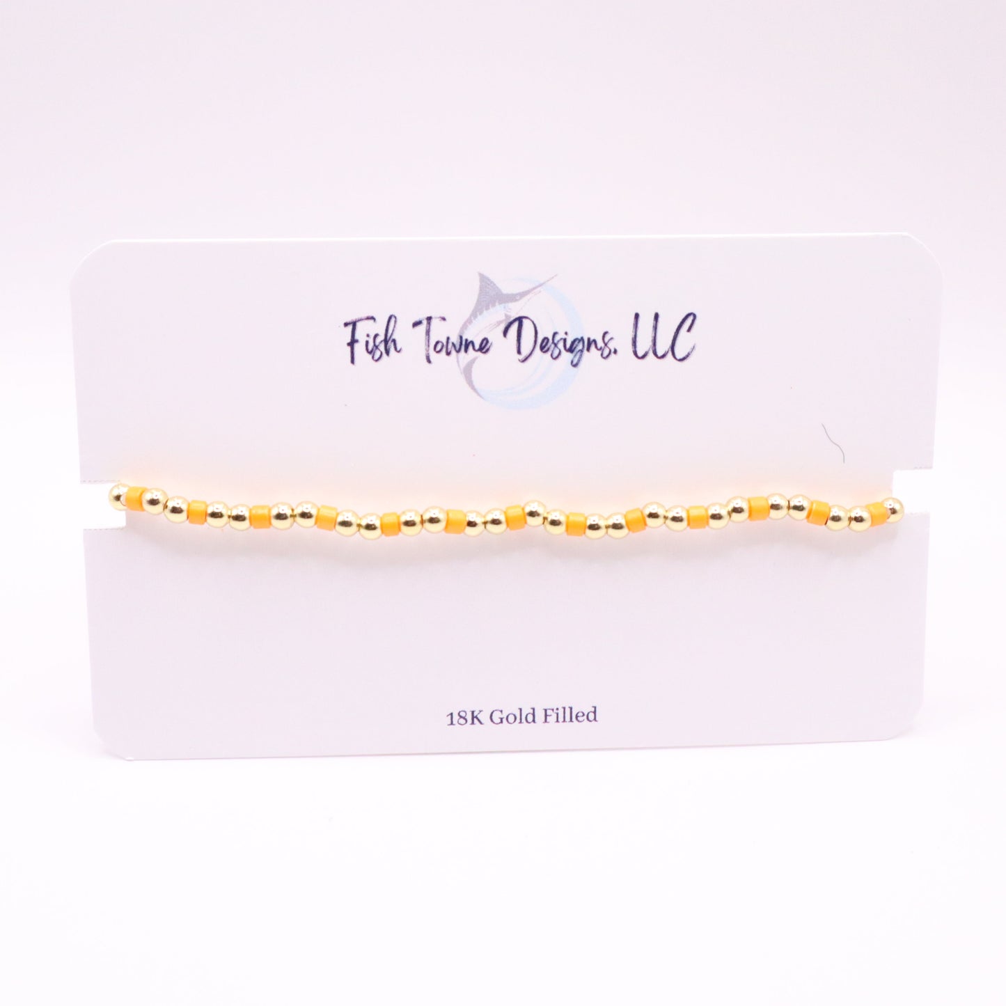 Gold and orange bracelet on a white card with 'Fish Towne Designs, LLC' branding.