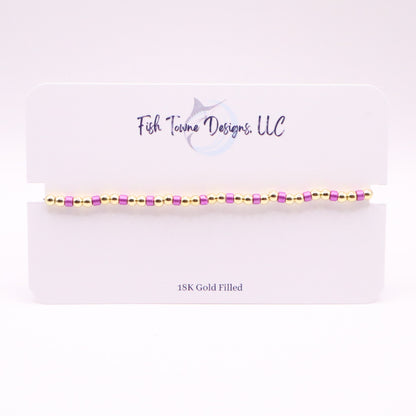  Gold and violet bracelet on a white card with 'Fish Towne Designs, LLC' branding.