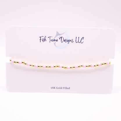 Gold and pink bracelet  on a white card with 'Fish Towne Designs, LLC' branding.